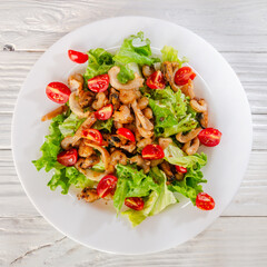 summer vegetable salad on a white dish on a wooden background