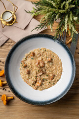 Creamy risotto with girolle mushrooms, directly above view on rustic old wooden table