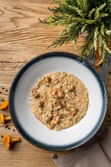 Creamy risotto with girolle mushrooms, directly above view on rustic old wooden table