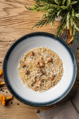 Classic italian risotto with forest mushrooms , top view on wooden background, herbs and mushrooms around