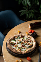 Stove baked pizza with mushrooms and parmesan on wooden table in a fancy restaurant, soft light, posh photography