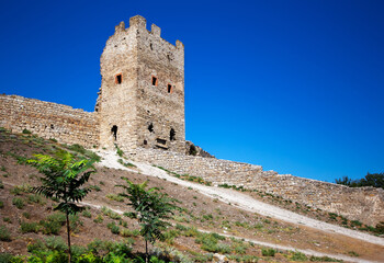 Ancient historic Genoese stone castle or fortress against the blue sky in Crimean peninsula. The place of interest in Crimea