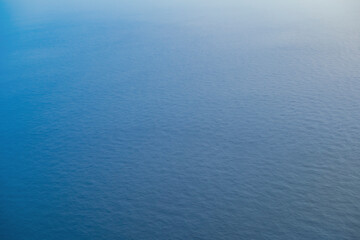 Fototapeta na wymiar 飛行機の窓から海を見下ろす