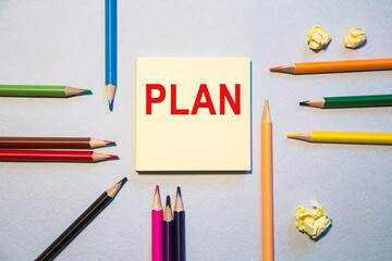 note with Flat lay space for text. The words plan. Office, colored paper, colored pencils. Marketing concept.