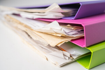 File Folder Binder stack of multi color on table in office.