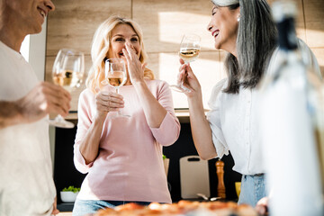 Happy adult friends talking on the kitchen