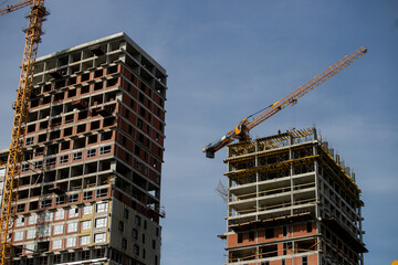 Preparing to pour a bucket of concrete into formwork.Tower crane lifting cement bucket during...