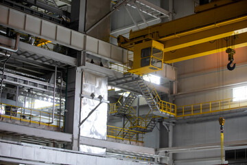 Part of an overhead crane in the background of an industrial workshop