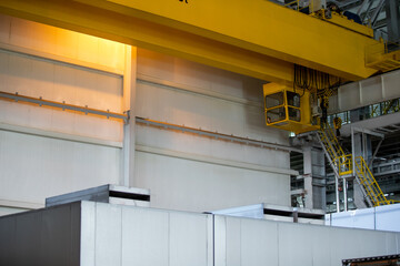 Part of an overhead crane in the background of an industrial workshop