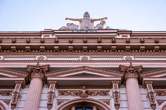 Old European Renaissance Style High School Building With Angle Statue On Top Low Angle Point Of View