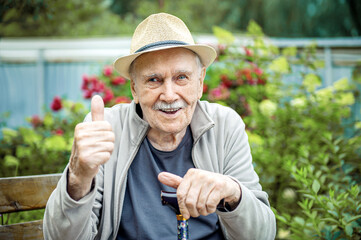Portrait of a smiling and confident senior 87 years old cute in a hat with a mustache. Happy active...