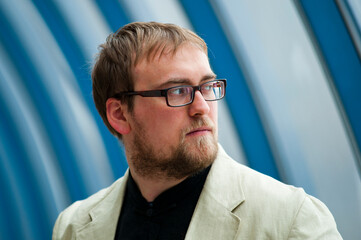 Portrait of a serious man with glasses and an unshaven face