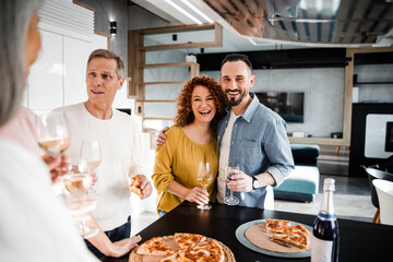 Happy couple is posing at camera and holding wine