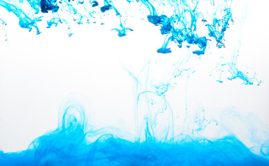 Closeup of a blue ink in water in motion isolated on white. Ink swirling underwater. Colored abstract smoke explosion effect. Abstract background with copy space..