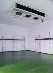 Empty cold room for food, with storage shelves and a refrigerator evaporator machine to produce cold and preserve the food