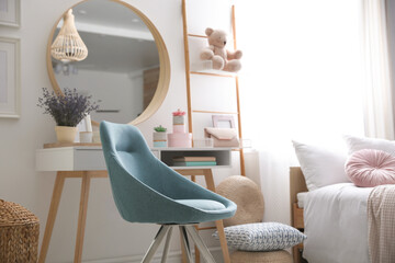 Comfortable blue chair in teenage girl's bedroom interior. Idea for design