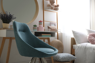 Comfortable blue chair in teenage girl's bedroom interior. Idea for design