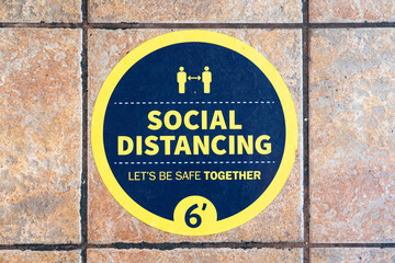 Fototapeta premium Circular sign on the ground encouraging social distancing