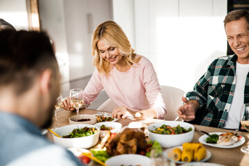 Happy friends gathering at the festive table in a cozy home