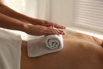 Young woman receiving hot towel massage in spa salon, closeup