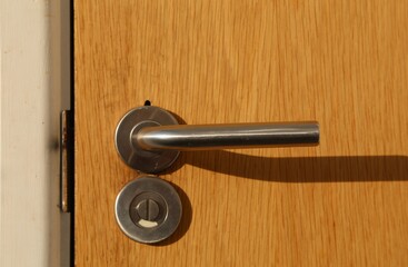 A metal door handle on an internal door.