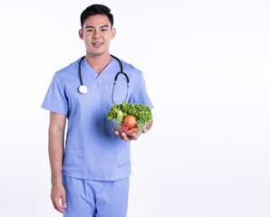 Asian young doctor holding vegetables on white background