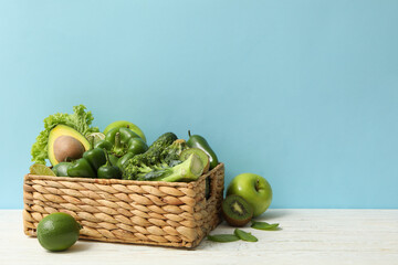 Basket with vegetable and fruits on blue background