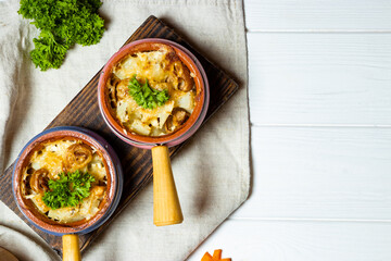 Julienne in pots, top view. French cuisine dish, baked potatoes with mushrooms
