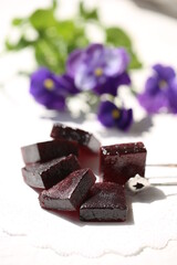 Handmade marmalade of dark color from grapes, on a white background.
