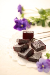 Handmade marmalade of dark color from grapes, on a white background.
