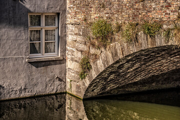 the light reflects under a bridge of Bruges