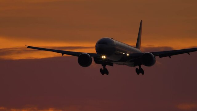 Airplane on final approach at sunset