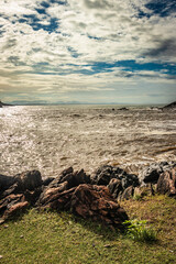 rocky sea beach with crashing waves and amazing sky at morning from flat angle