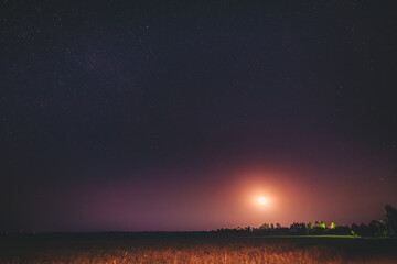 Moonrise Above Belarusian Village In Eastern Europe. Belarusian Countryside In Summer Starry Night
