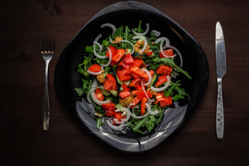 pepper cucumber and onion salad seasoned with mustard on a plate on a wooden table