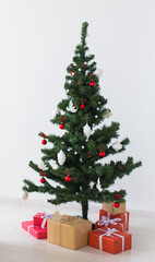 Holidays, celebration and home concept - christmas tree and presents.