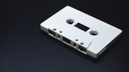 Old audio cassettes on dark wooden background.
