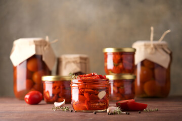 Sun-dried tomatoes in jar with spices and herbs. Autumn seasonal pickled or fermented colorful vegetables. Fall home food preserving or canning