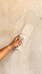 Tiler's hand.bricklayer plaster a wall inside a building