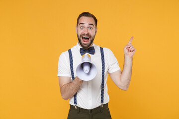 Shocked amazed young bearded man 20s wearing white shirt bow-tie suspender posing standing...