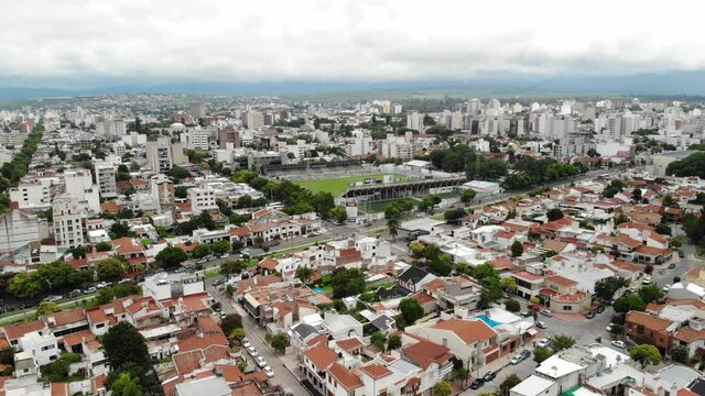 Vista aérea sobre la zona de Portezuelo en Salta Capital, el drone volando al frente con vista a un estadio de futbol soccer.