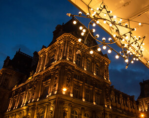Christmas in Paris. Night view of illuminated Hotel de ville (city hall) building through Christmas lights decoration at Rivoli street.