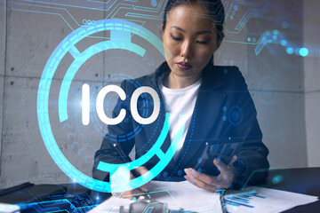 Businesswoman taking notes and ICO hologram. Double exposure. Business technology initial coin...