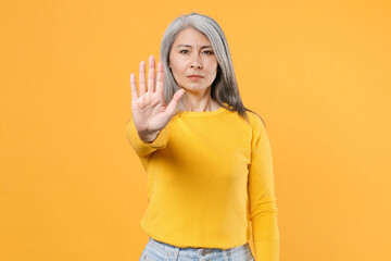 Dissatisfied displeased serious gray-haired asian woman wearing casual clothes standing showing...