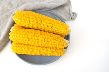 grilled corn, boiled corn on a wooden white plate. Vegetarian food, healthy food.