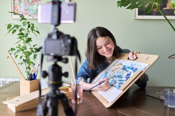 Artist, teenage girl, draws and records on video camera for his blog