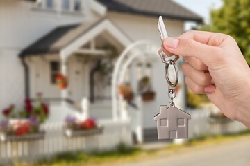 House key in hand on the blurred house background