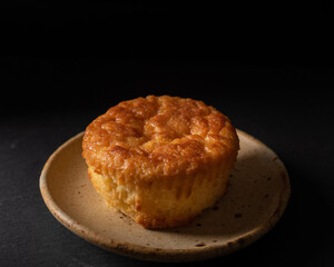 Golden Cornbread Muffin Isolated on rustic plate over dark background