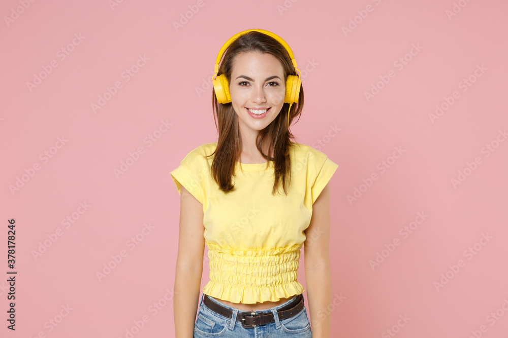 Wall mural smiling beautiful attractive young brunette woman 20s wearing yellow casual t-shirt posing listening