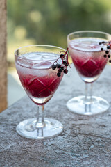 Water with ice and black elder syrup, with elderberries